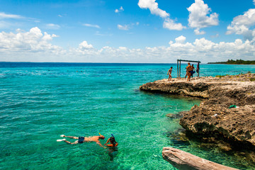 BAY OF PIGS, CUBA -SEPTEMBER 2015- Tourists practices snorkeling on the clear waters of Bay of Pigs, Cuba.  - obrazy, fototapety, plakaty