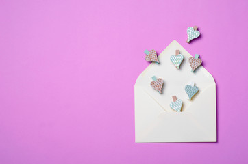 White Envelope on Purple Background and Heart Shaped Pins, Top View