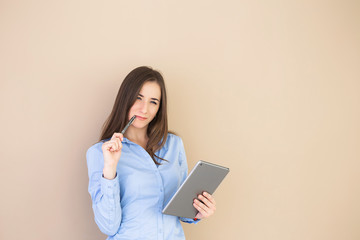 A business woman using tablet isolated on beige background