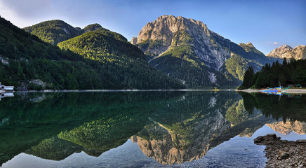 Morning sun lights on mountains above Lago del Predil in the Julian Alps, in Slovenia. Calm water and beautiful reflections