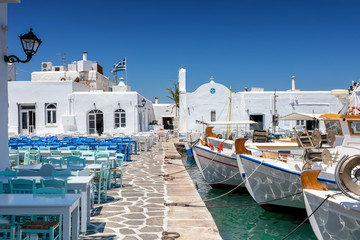 Die Hafenpromenade mit Restaurants und Tavernen direkt neben den Fischerbooten in Naousa, Paros,...
