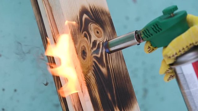 Fire flame concept Burning wood burner burns wood planking fire flames wood texture worker at constructing tool concept 