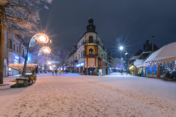 Main street in Zakopane in the snow evening - obrazy, fototapety, plakaty
