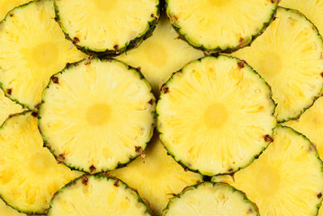 Pineapple juicy yellow slices background. Top view.