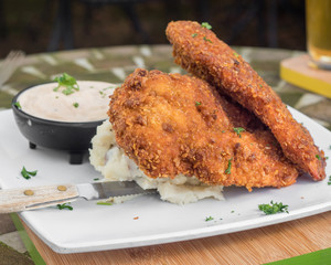 Breaded and fried chicken breast served with warm mashed potatoes. Classic, hearty, and filling American comfort food. 