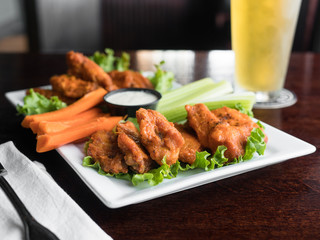 Buffalo hot wings. Spicy buffalo chicken wings served with carrots and, celery, and bleu cheese. Spicy chicken wings. 