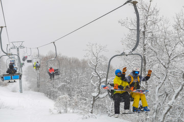 Fototapeta na wymiar People are lifting on ski-lift in the mountains
