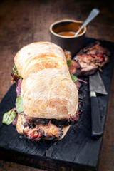 Traditional barbecue pulled pork piece of Bosten butt as sandwich with lettuce as closeup on a...