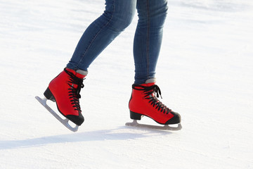 feet in red skates on an ice rink