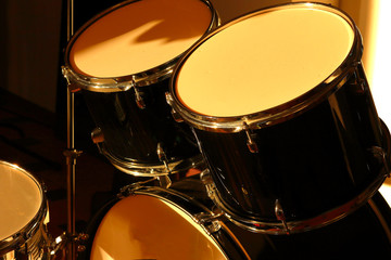 Plakat Drum set illuminated by the rays of the setting sun in a music studio. Closeup.