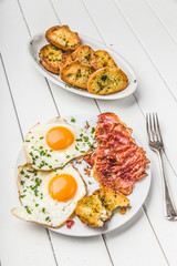 bacon and eggs for breakfast with chives and bread