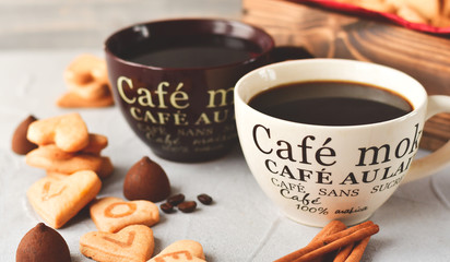 romantic morning: two cups of coffee with cookies in the shape of hearts, on the cookie letters LOVE. Valentine's day. selective focus. on the сup description in French(mocha coffee, coffee with milk)