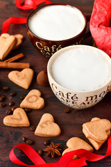 Fototapeta na wymiar romantic morning: two cups of coffee with cookies in the shape of hearts, on the cookie letters LOVE. Valentine's day. selective focus. on the сup description in French(mocha coffee, coffee with milk)