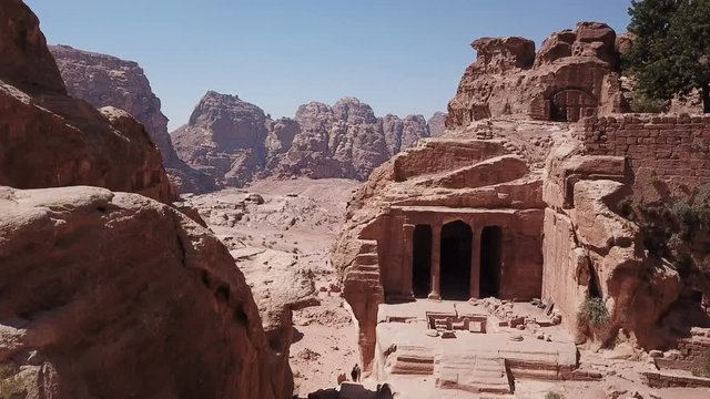 Drone flying past ancient archaeology temple in desert rocks, aerial view