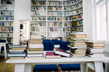Stack of books in the library and blur bookshelf background