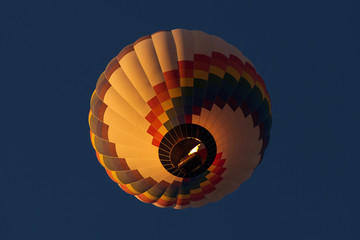 View from bellow a colorful hot air ballloon with beautiful blue sky in background