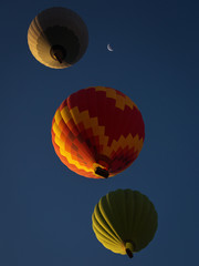 View from bellow a colorful hot air ballloon near the moon with beautiful blue sky in background