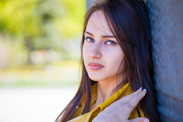 Portrait of young beautiful brunette in yellow jacket