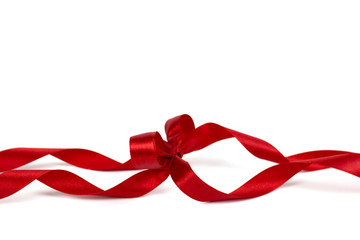 Decorative silk red ribbon with a bow on isolated white background.