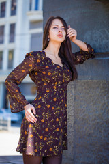 Fototapeta premium Beautiful brunette woman in sexy brown dress