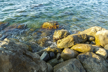 Fototapeta na wymiar Large stones and fragments of rocks in the sea.