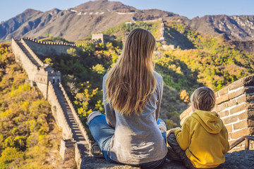 Happy cheerful joyful tourists mom and son at Great Wall of China meditate on vacation trip in Asia. Chinese destination. Travel with children in China concept