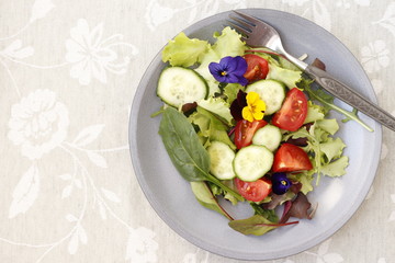 Vegetarian salad with fresh vegetables and flowers.