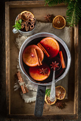 Sweet and delicious mulled red wine on rustic table