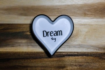 Dream big on heart shaped pottery with attractive wooden background 
