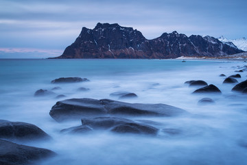 Fototapeta na wymiar Beautiful landscape view with water in motion and mountain in background. Lofoten, Norway