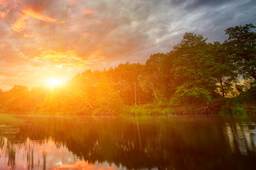 Sunset long the banks of the Amazon river. The tributaries of the Amazon traverse the countries of...