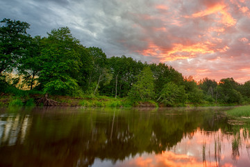 Sunset long the banks of the Amazon river. The tributaries of the Amazon traverse the countries of Guyana, Ecuador, Peru, Brazil, Colombia, Venezuela and Bolivia. Sunset on the river