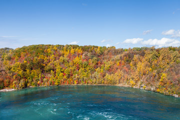 Niagara Whirlpool.  The view across Niagara Whirlpool located on the Canadian and American border.  In the background can be seen the colorful foliage of trees during the fall.