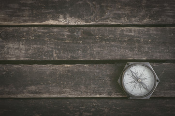 Vintage compass on the wooden table background with copy space.