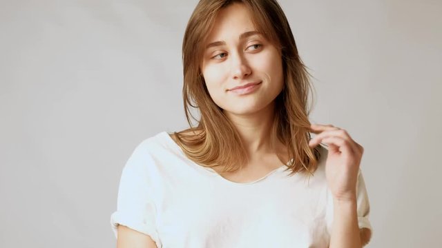 Young playful attractive woman biting lips, flirting, playing with hair on camera