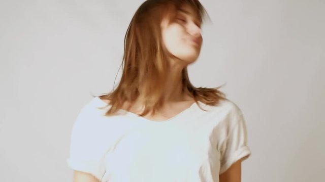 Young playful attractive woman flirting, playing with hair and winking at camera