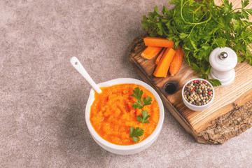 Bright tasty pureed carrot soup in clay bowl