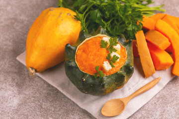 Bright tasty pureed pumpkin soup served in a hollowed pumpkin
