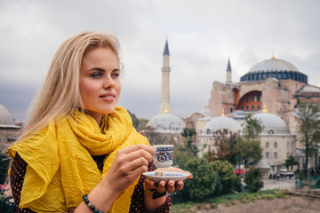 Woman with turkish coffee on Hagia Sophia bacground, Istanbul