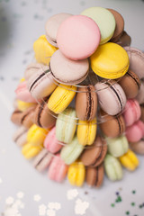 colorful french macarons multilevel cake pyramid on plastic dessert stand.