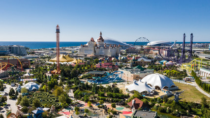 RUSSIA, SOCHI - JUL 27, 2018: Amusement park near hotel Bogatyr at summer sunny day. Aerial view. Photo with noise from action camera