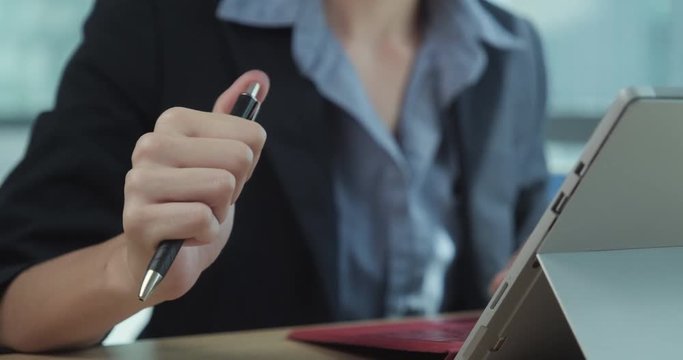 Bored Businesswoman Cliking Pen Repeatedly While Working at Office
