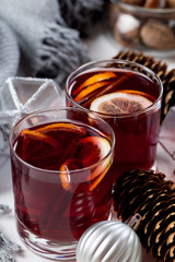 Mulled wine in glasses with orange and spices with gray scarf.