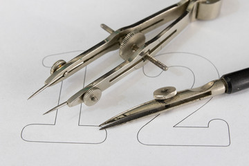 Fototapeta premium A companion for drawing circles on a white piece of paper. Drafting accessories for drawing technical drawings.