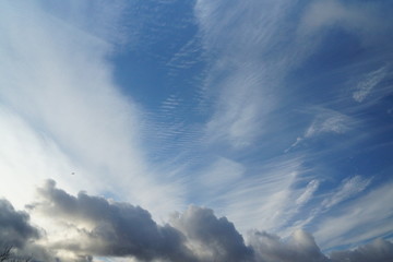 Fototapeta na wymiar blue cloudy sky with a plane