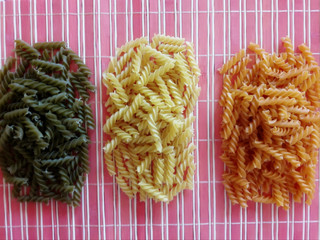 Uncooked multicolor fusilli pasta. Sorted by color.