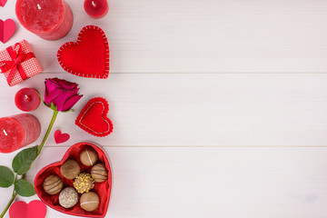 Valentines day romantic decoration with roses and chocolate on a white wooden table. Top view, copy space.