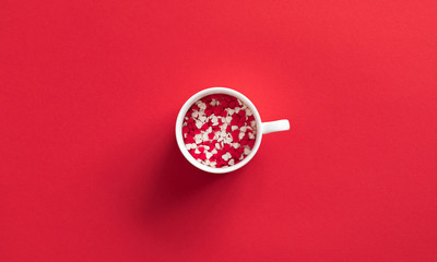 Elegant composition for Valentine's day. White cup, red and white heart on red background. Valentine day concept for design. Flat lay, top view, copy space