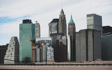 Close-up view of Manhattan skyline seen from the beautiful Brooklyn bridge. Cloudy day in Manhattan, New York City, USA.