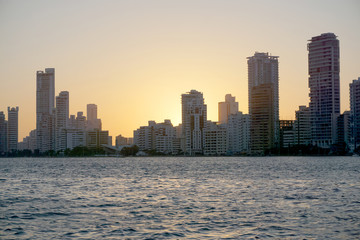Fototapeta na wymiar Cartagena / Colombia - 12 25 2018: Panoramic view of the coastline of the city and the sea with blue sky with some boats or ships with a sunset and buildings